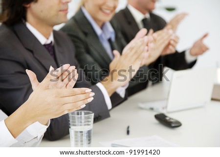 business people at a board meeting, clapping