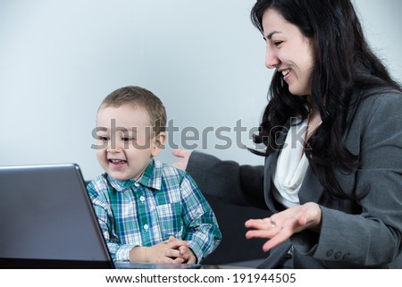 Mother and her son at the computer laughing as a happy family