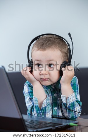 Baby boy with headphones watching the computer