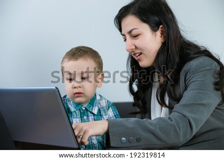 Mother with son at the computer laughing as a happy family