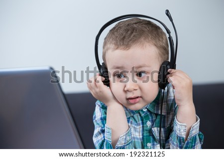 Baby boy with headphones at the computer