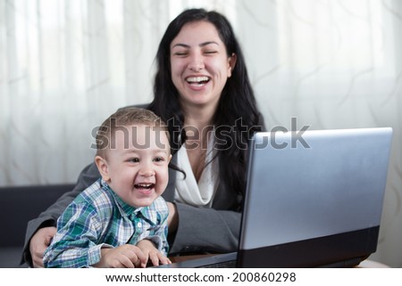Mother with her boy have a laugh in front of the computer while watching educational material