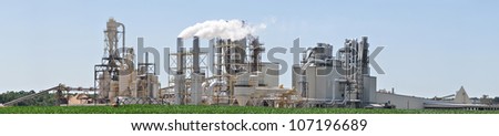 Smoke stacks billowing out steam and vapor from a manufacturing facility