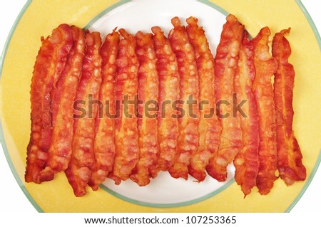 Strips of cooked bacon on a yellow plate