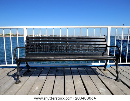 Wooden bench on the pedestrian passage over the sea water.