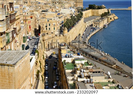 VALLETTA, ISLAND OF MALTA - NOVEMBER 4, 2014. Sandstone buildings in  the old harbor and Victoria Gate in Valetta, capital of Island of Malta