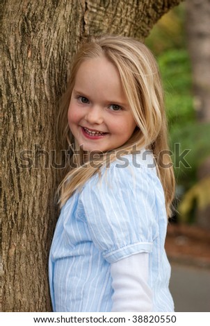 Young girl climbing tree and smiling