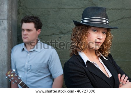 Man and woman posing  against concrete wall