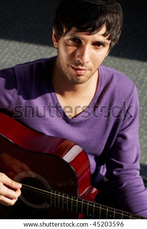 young student playing an acoustic guitar