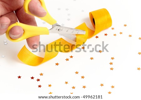 scissors cutting a yellow gift ribbon