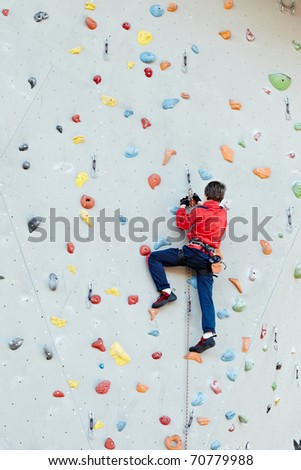 Man on artificial exercise climbing wall