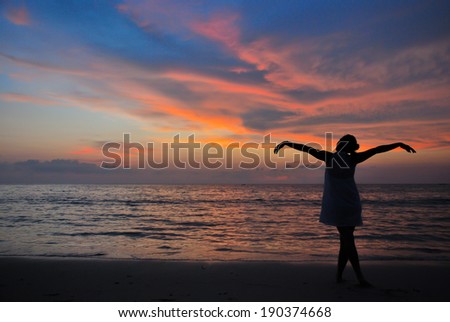 In a summer vacation.Young mother stand on the beach at beautiful sunset feel freedom