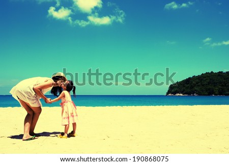 Retro style In summer vacation. Young mother and her kid playing on the beach
