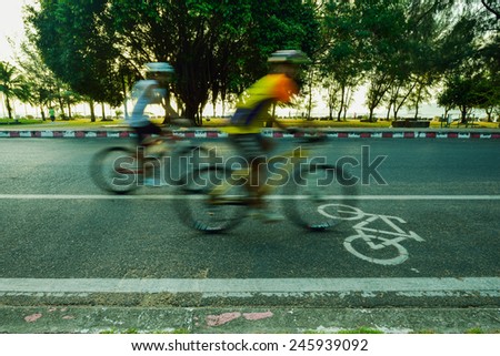 Motion blurred silhouette a part of cyclist going fast on a bike lane
