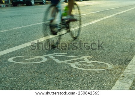 Motion blurred silhouette a part of cyclist going fast on a bike lane