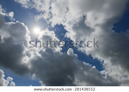 Cloudscape with the sun rays radiating from behind the rainy clouds
