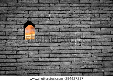 Sunset sky view in small window or hole on black and white brick wall background freedom concept