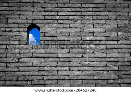 Blue sky with white cloud small window or hole on black and white brick wall background freedom concept