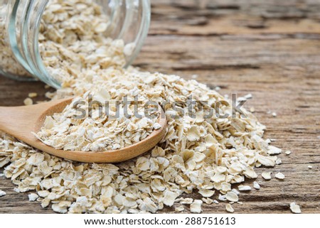 Dry rolled oat flakes oatmeal on old wooden table