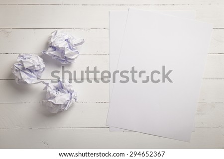 White paper and Crumpled paper balls on white color wood plank background with space for text