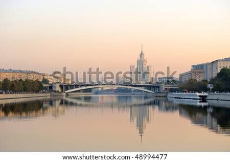Russia. Moscow. View on classical Stalin\'s tower building on Kotelnicheskaya quay across Moskva river at a sunrise and Ust\'inskiy bridge