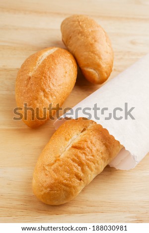 Bread in paper bag on wooden table