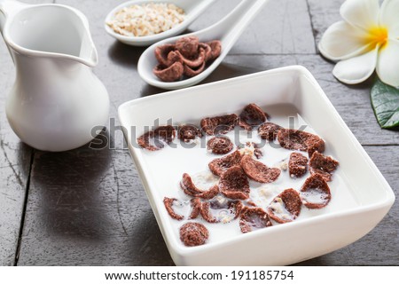 Breakfast - milk with chocolate corn flakes cereal in bowl