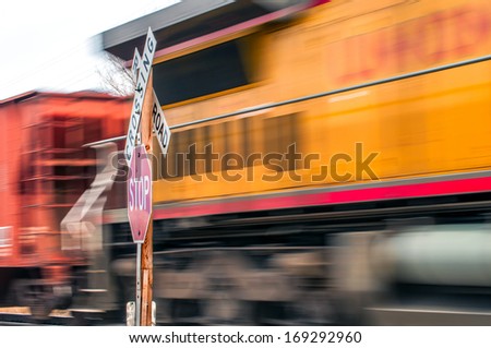 Waiting at a railroad crossing while a fast freight train passes by.