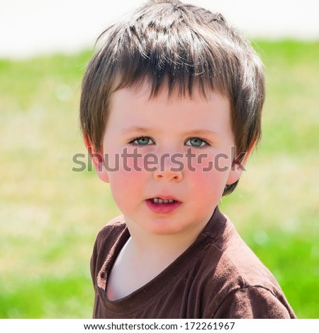 Cute little boy takes a break from playing outside to get his picture taken.
