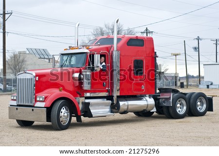 Smiling woman driving a semi truck without a trailer.