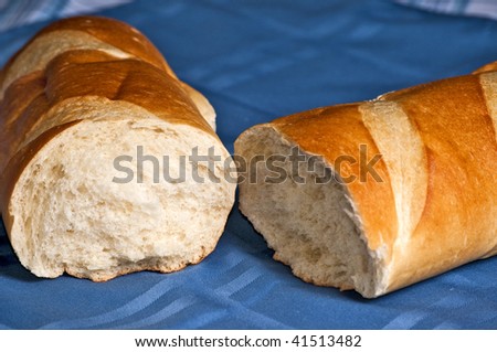 A delicious loaf of French bread broken open ready to butter and eat.