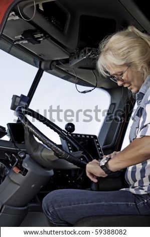 Woman truck driver getting out her log book and getting ready to start her trip.