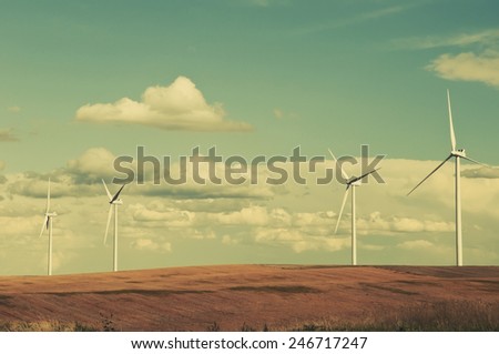 Large wind turbines gathering electricity out of the wind in eastern Colorado, USA. Retro instagram look.