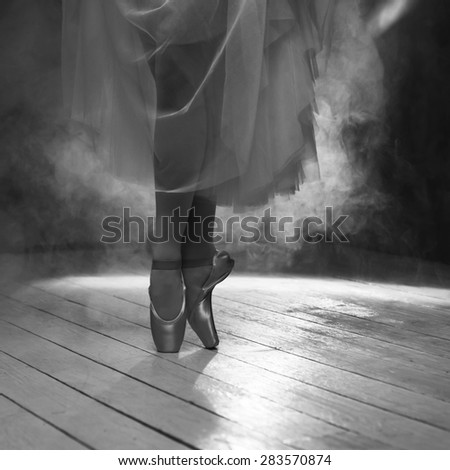 The feet of a ballerina dancing in smoke