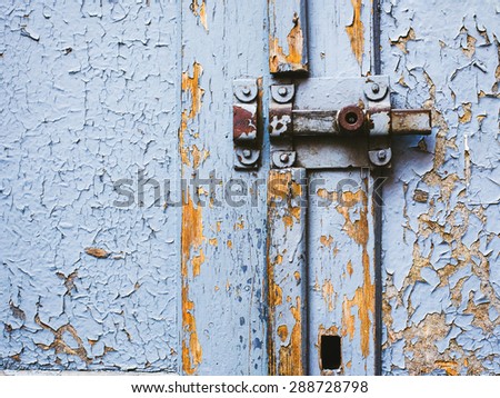 Wooden door with cracked paint and door latch