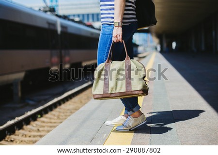 Woman holding a bag at a train station