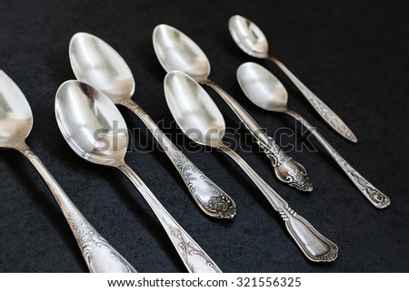 Silver spoons on the grey stone background