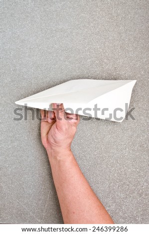 hand with origami plane (paper air-plane)
