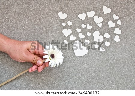 flower of love (hand giving white flower with paper cut in heart shape)