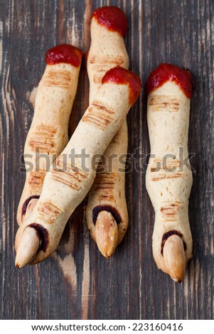 Halloween scary finger cookies on the wooden desk