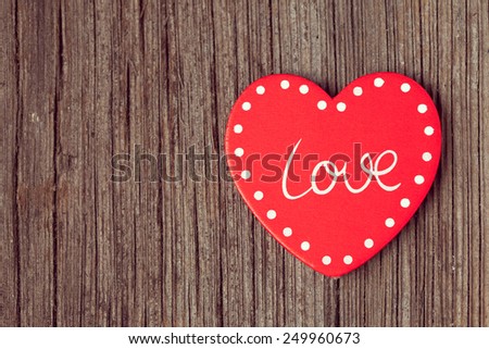Red valentine\'s day holiday heart  on retro wooden background with vintage instagram toning