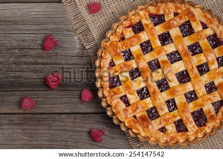 Raspberry pie with fresh raspberries and jam on vintage textile texture. Top view