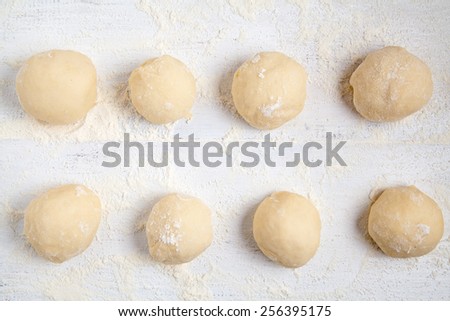 Rolled balls of dough on white table