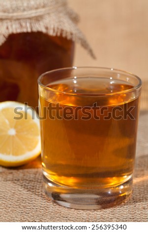 Kombucha superfood pro biotic tea fungus beverage in glass with lemon on white background