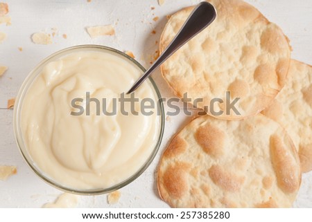 Custard pastry cream on white vintage background. Preparation of sweet pastry custard cream in a bowl. Pastry filling.