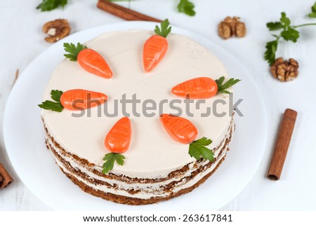 Homemade carrot cake with little carrots on top on white background