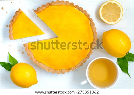 Homemade fruit lemon tart pie with green tea on white rustick table background