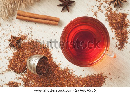 Rooibos traditional organic dieting drink. Healthy superfood beverage rooibos african tea with spices on vintage wooden background