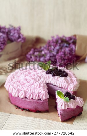 Berry purple souffle cake. Traditional delicious homemade baked sweet decorated with blackberry and whipped cream. Rustic style, natural light.