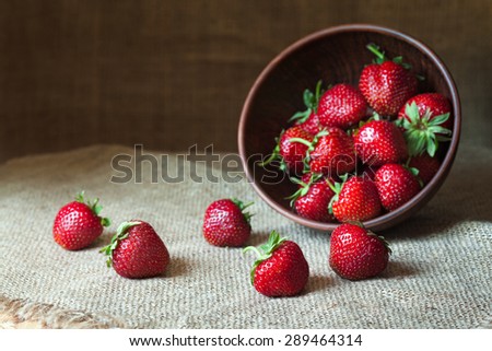 Strawberry natural healthy nutrition organic food in rustic clay dish on vintage kitchen background. Vegetarian, full of vitamin dessert. Dark food photo, rustic style, natural light.